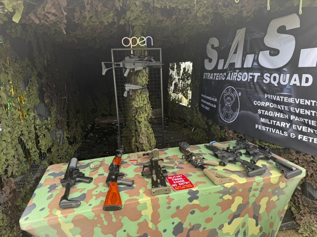Replica rifles and pistols laid out ready on the range table