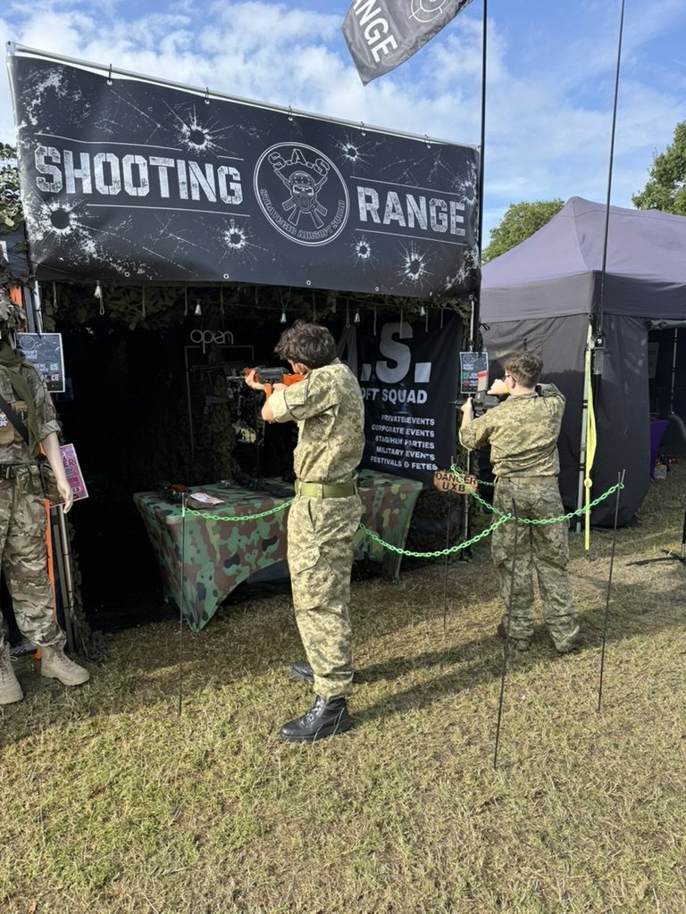 A visitor shooting on the range under the SHOOTING RANGE banner